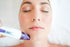 Woman receiving facial treatment with purple skincare device for luxury skin care routine